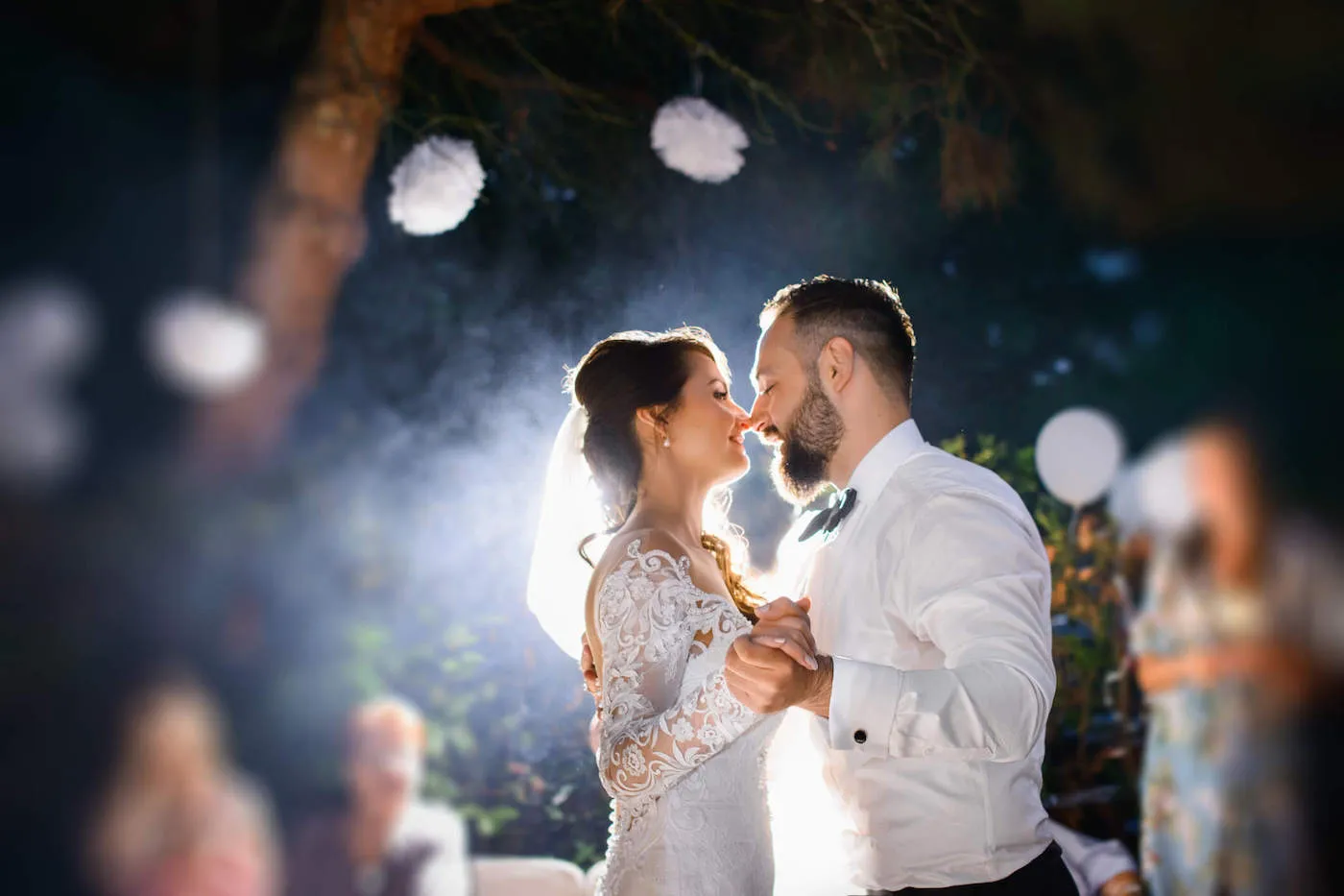 A bride and groom hold each other's hands as they dance on their wedding night.