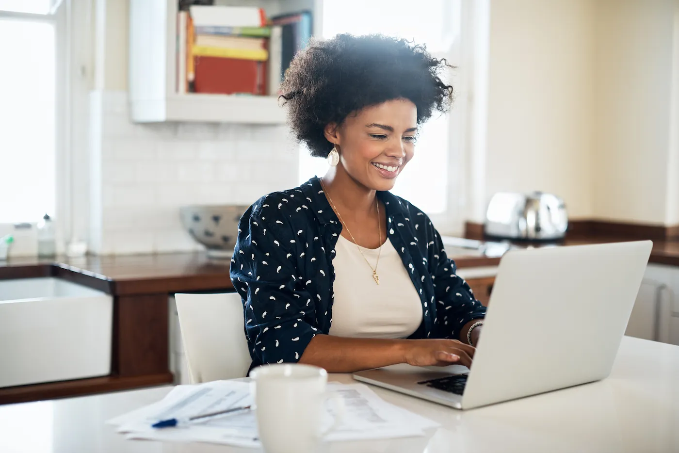 A woman researching how to rollover leftover 529 funds into a Roth IRA on a laptop.