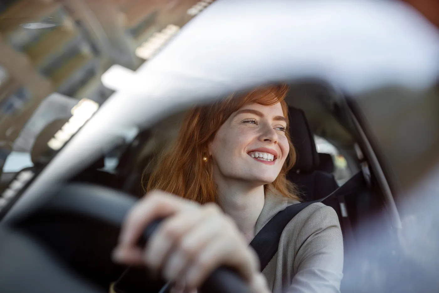 A young woman driving her car at sunset.