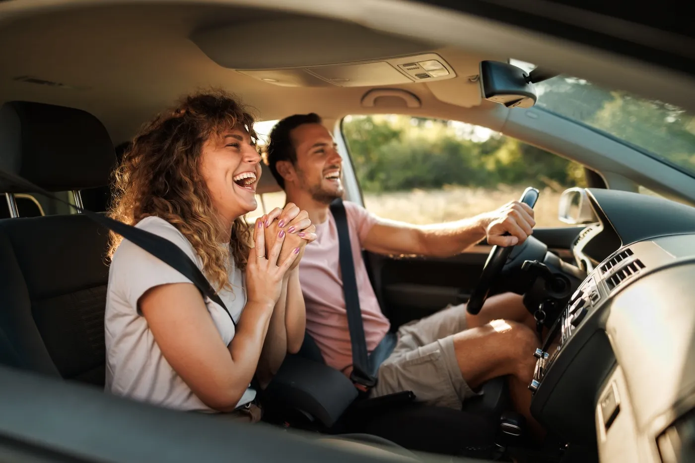 Young couple shares lighthearted moments and laughter during their adventurous car journey.