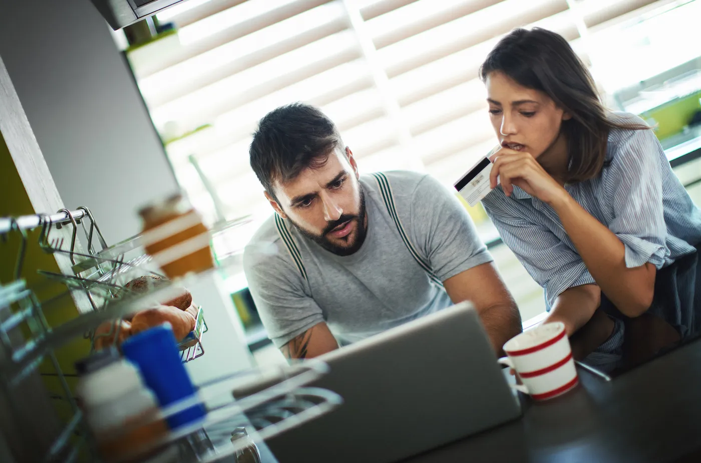 Closeup front view of a mid 20's couple figuring out how to recover financially from buying their house.