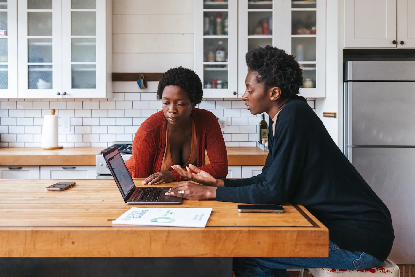 Couple looking at laptop on kitchen island researching mortgage borrowing.
