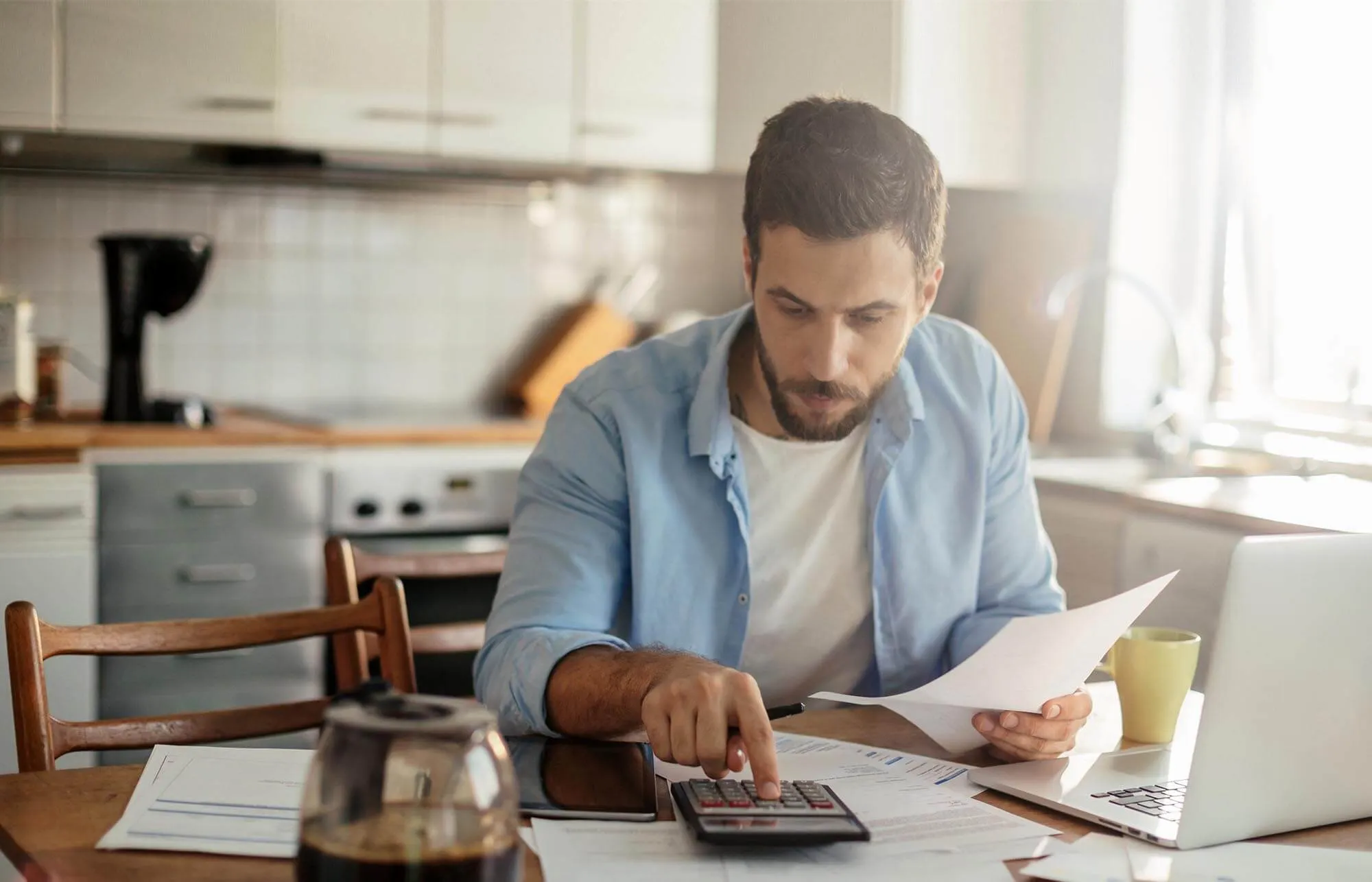 A man using a calculator while he holds a document.
