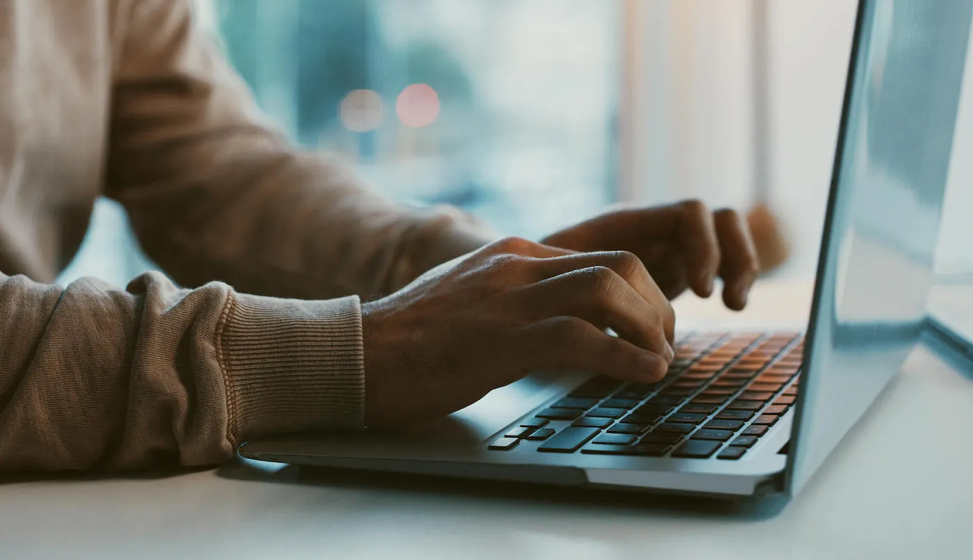 Person typing on laptop.